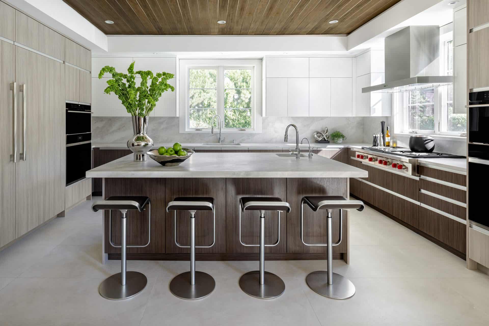 Minimalistic kitchen allows artwork to take center stage. Artcraft cabinets feature slab doors and integrated hardware.