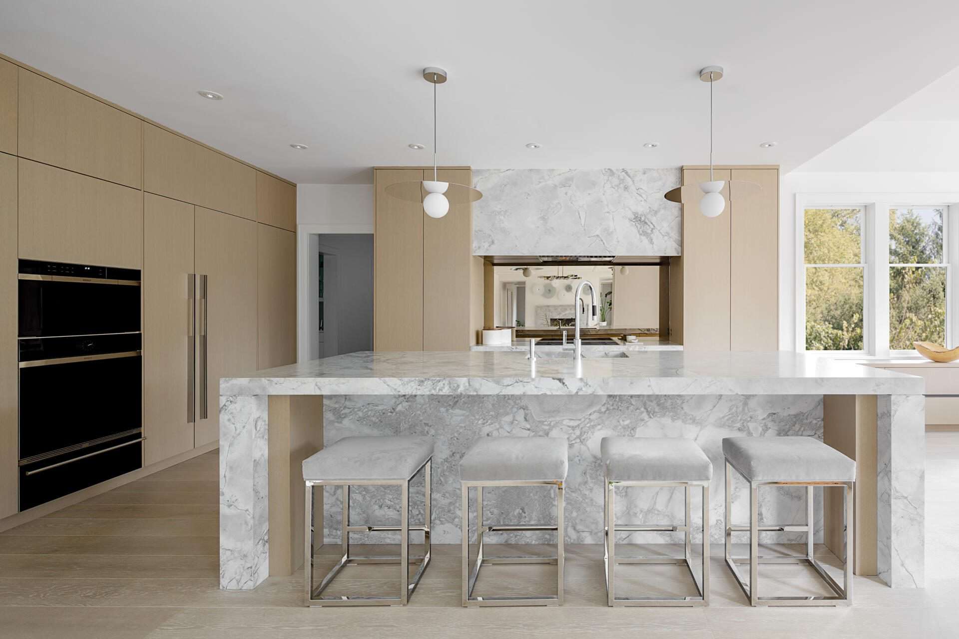 Contemporary kitchen features Caesarstone nougat countertops, glass and alumasteel accents and Artcraft horizontal grain quarter sawn oak and white gloss cabinetry.