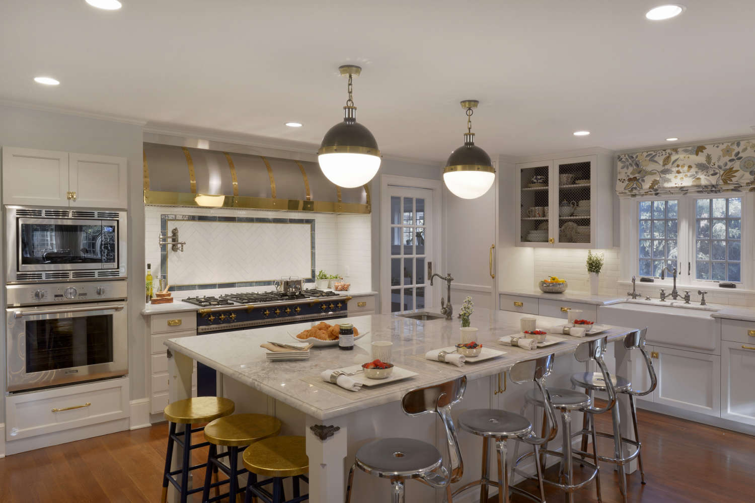 Expansive Bilotta kitchen in Scarsdale features La Cornue range with brass accented hood and Kyoto White and Kyoto Steel backsplash by Artistic Tile.