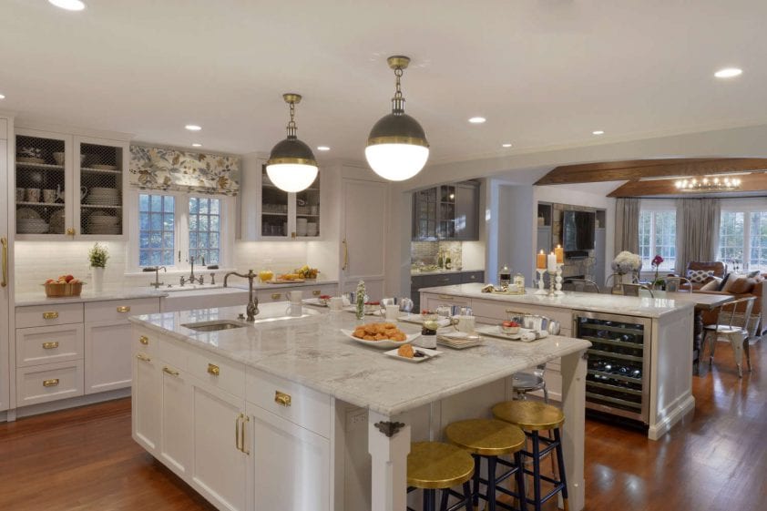 Classic kitchen featured marble topped center island and Bilotta cabinetry in Paperwhite with brass hardware.