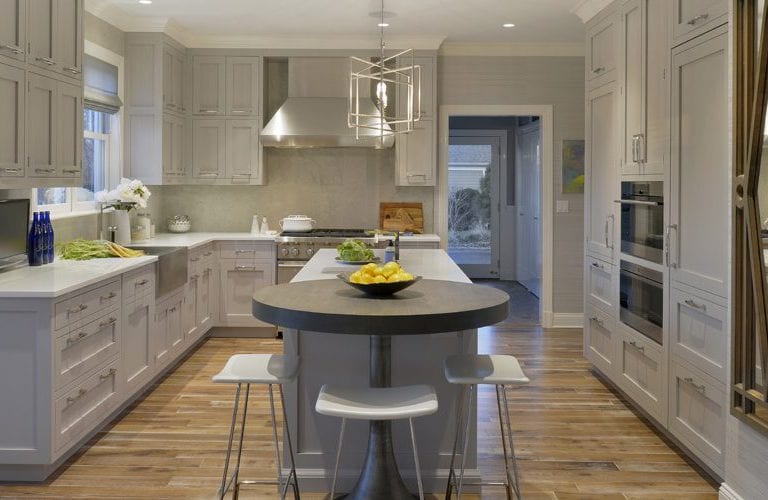 Traditional kitchen features double-stacked Bilotta Collection cabinets, wood block pedestal table, limestone backsplash and glass counters.