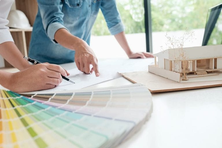 Architect and designer review kitchen plans and color chips.