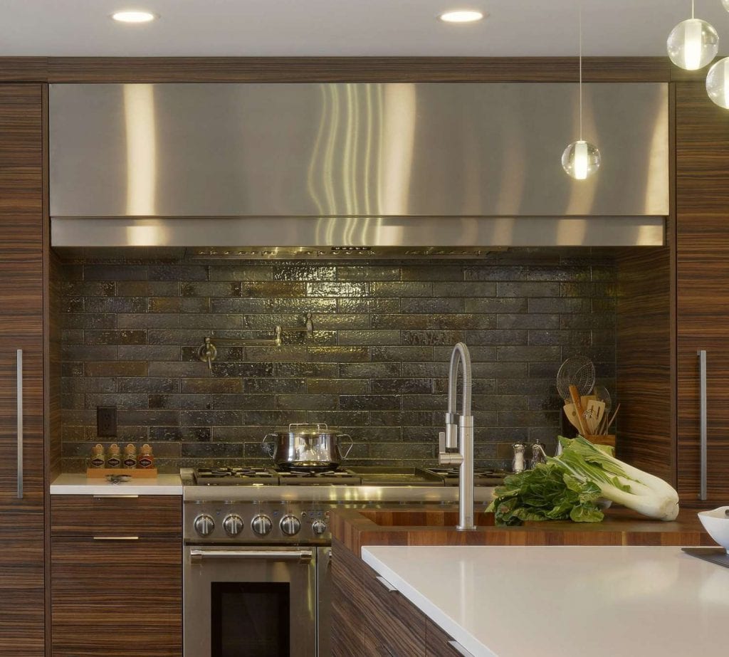 Kitchen features LP Cinque Terre range and stainless hood, dark wood veneer Artcraft cabinets and  Kyoto Steel ceramic tile backsplash.