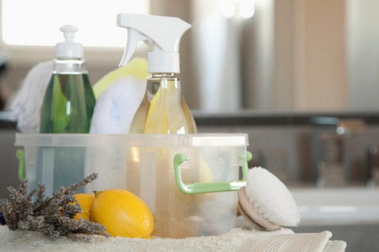 Container of kitchen cleaning products: spray bottles, soap lemon and lavender.