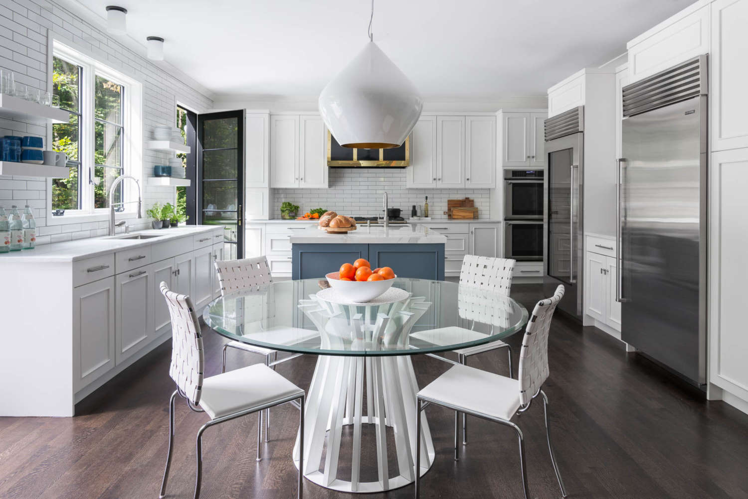 Highly functional kitchen features painted custom cabinetry by Bilotta, white Neolith Classtone countertops and a white subway tile backsplash as a backdrop for bold accents.