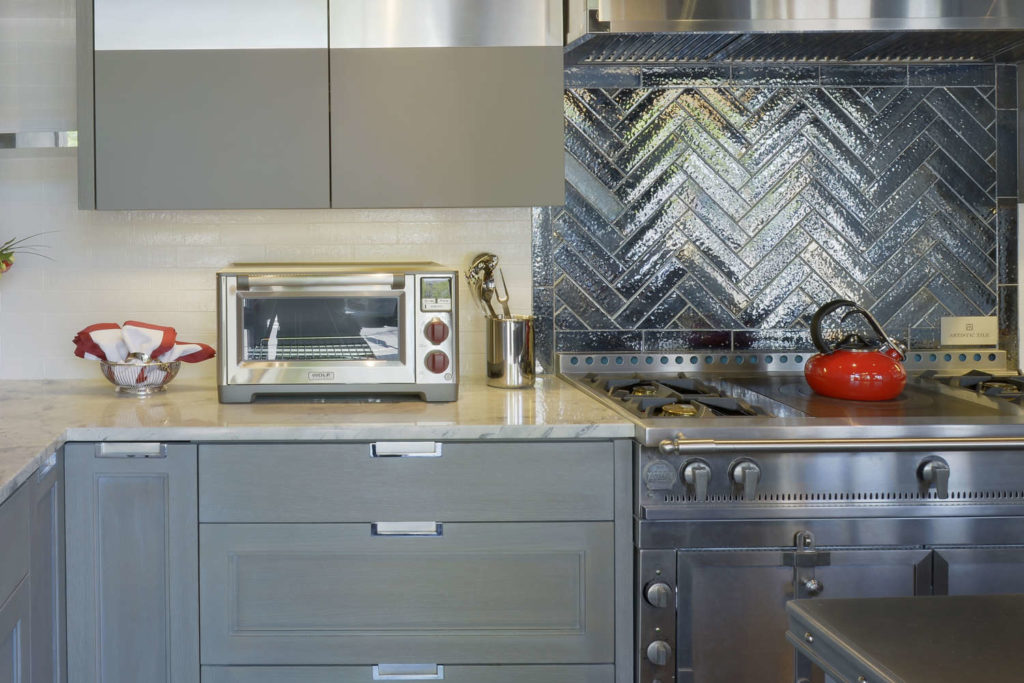 Anne Joyce's Art of the Table Kitchen - red kettle pops against stainless and metallic tile