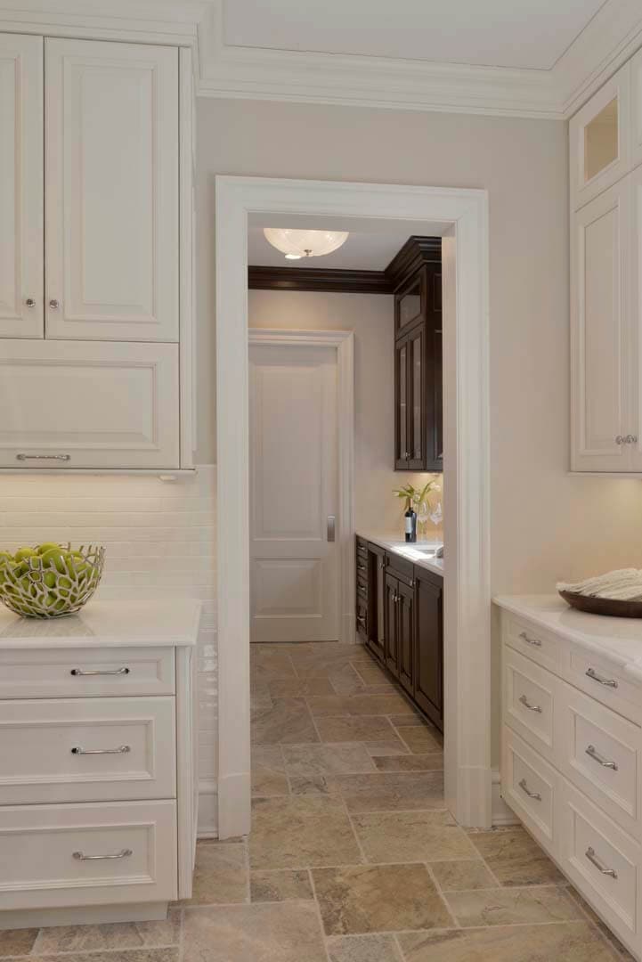 Classic kitchen and pantry features a mix of white painted and cherry stained Bilotta cabinetry and travertine flooring