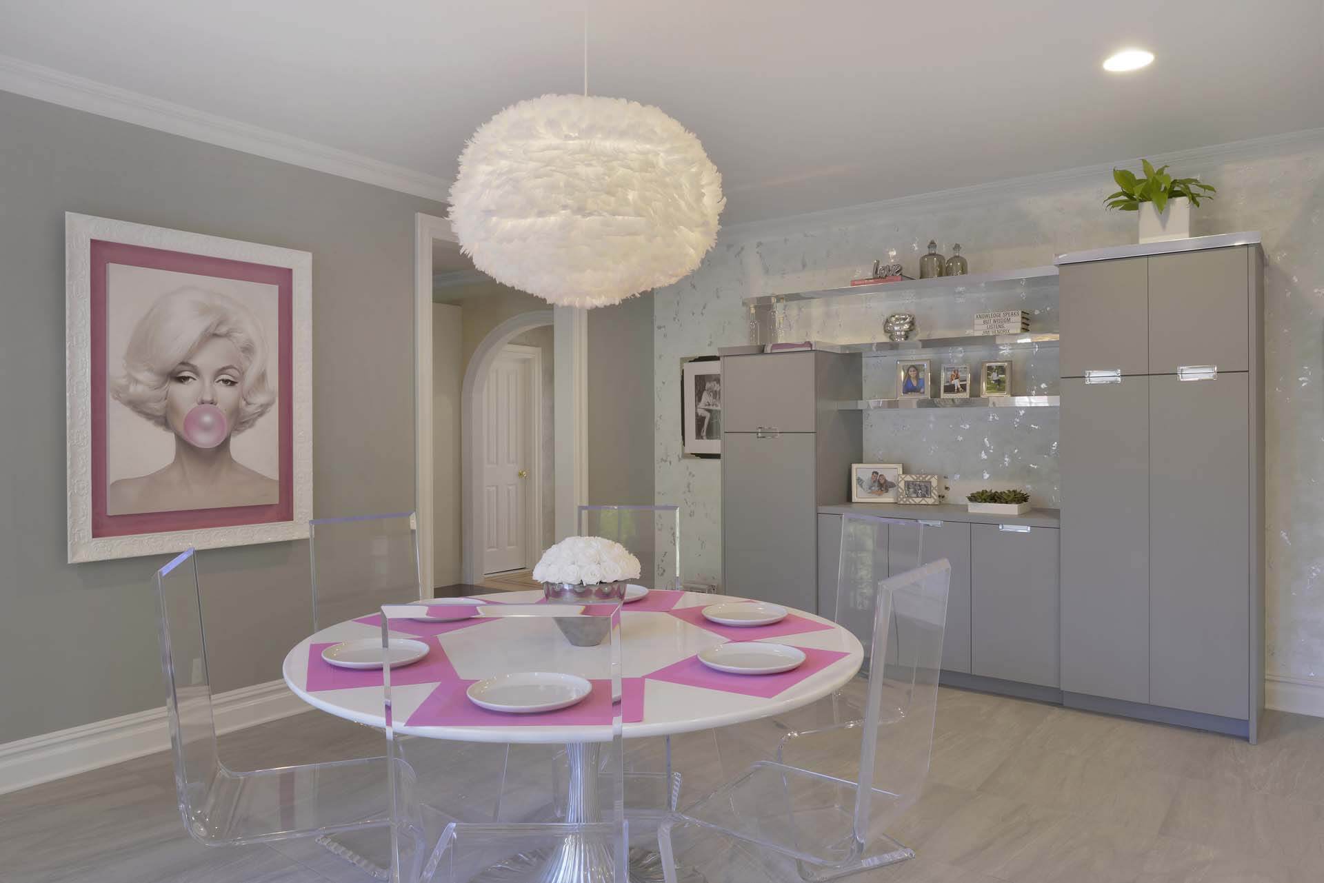 Playful kitchen features Bilotta cabinetry with silver accents and dining area with feathered chandelier.