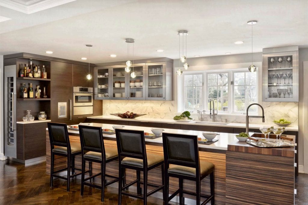 Contemporary kitchen with a mix of materials: dark textured laminates, stainless steel, glass, Calacatta Gold marble.