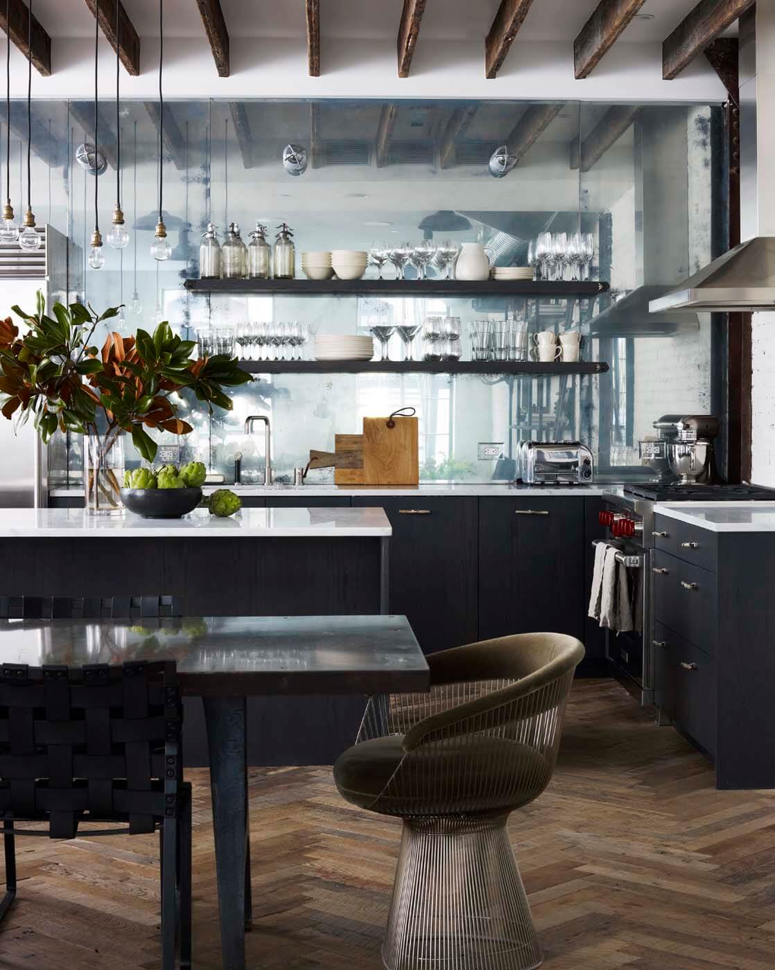 NY loft kitchen features dark veneer Artcraft cabinetry, mirror backsplash, floating shelves and white brick walls.