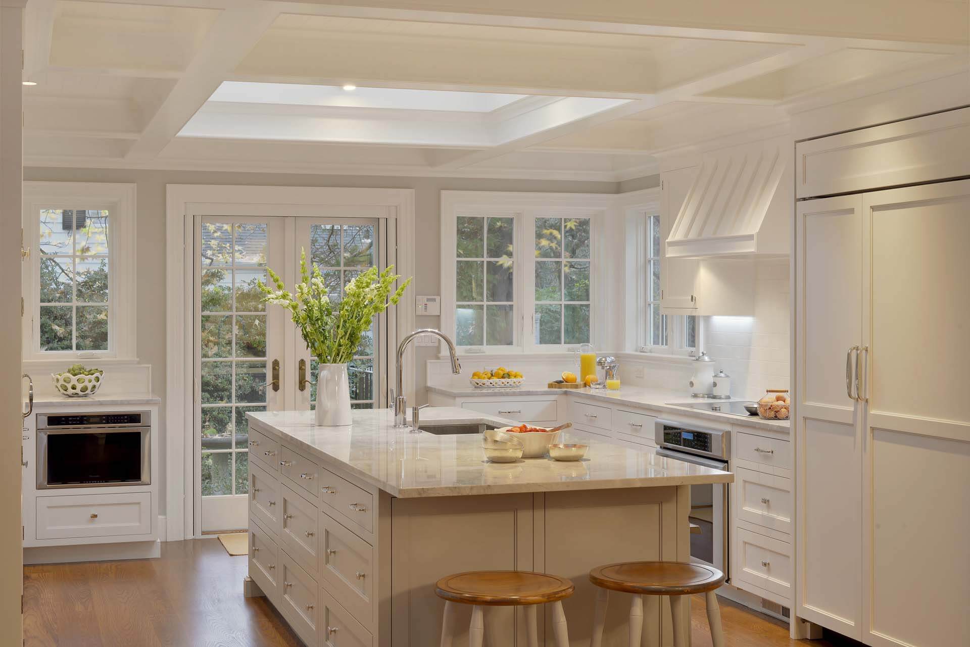 Elegant light-filled Pelham NY kitchen features Super White Rutt cabinetry, quartz countertops and marble subway backsplash.