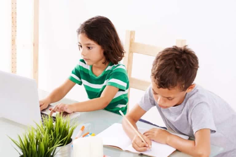 Children doing homework at a kitchen desk