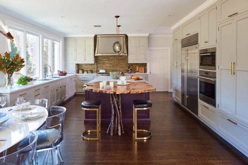 Eclectic, elegant kitchen features pale taupe perimeter cabinetry and a deep eggplant island with furniture legs.