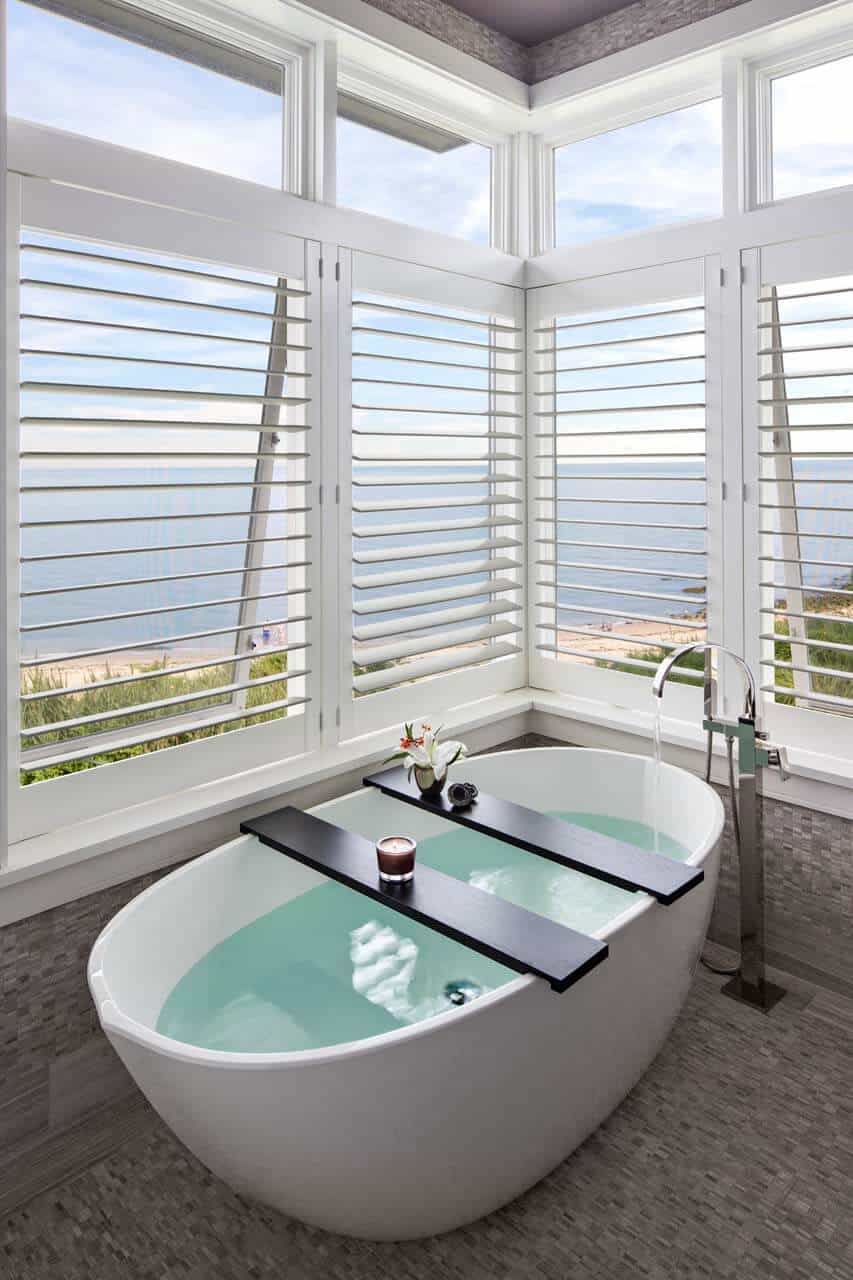Elegant bathroom features soaking tub with window view.