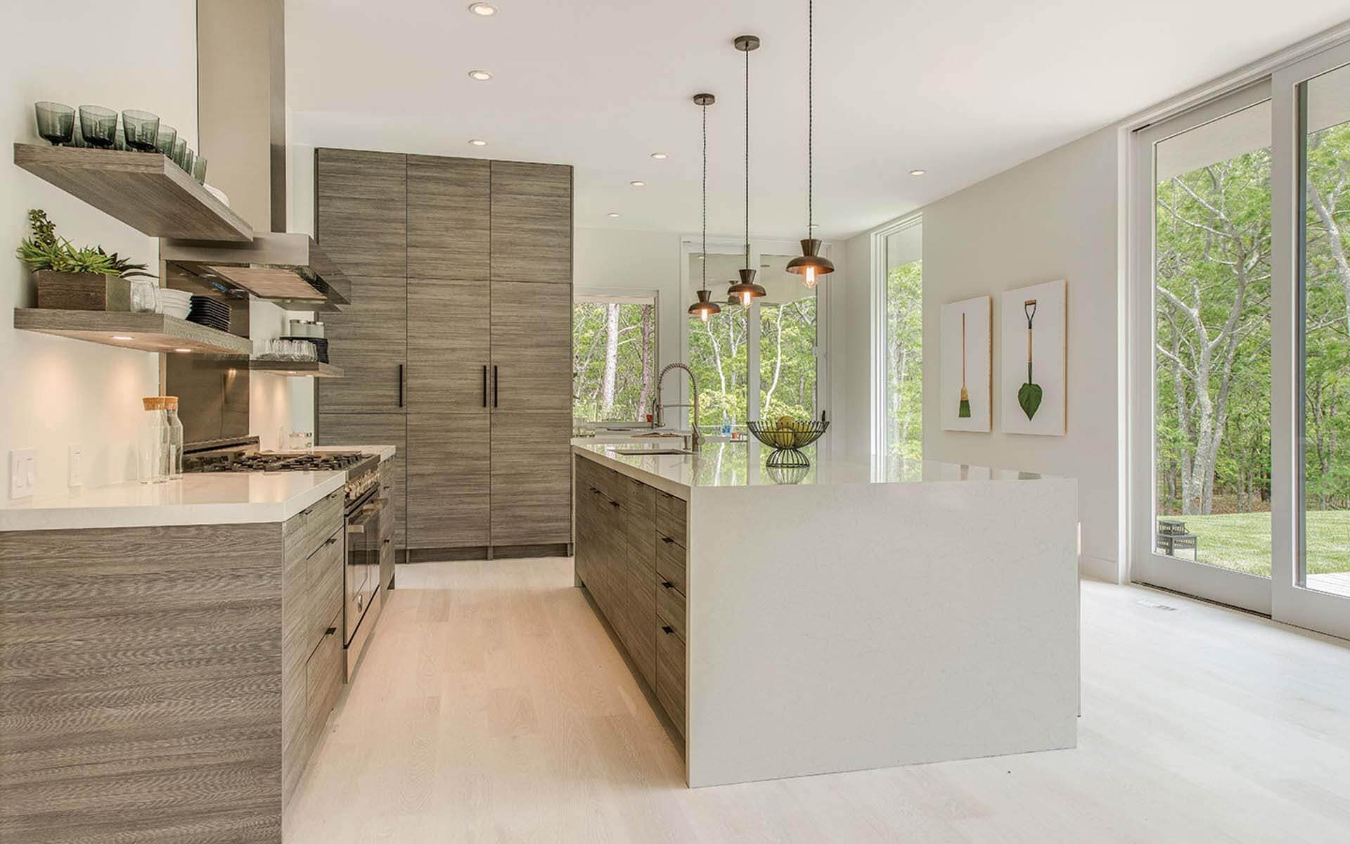 Horizontal laminate cabinetry adds texture to a monochromatic contemporary kitchen  in The Hamptons. Floor to ceiling windows.