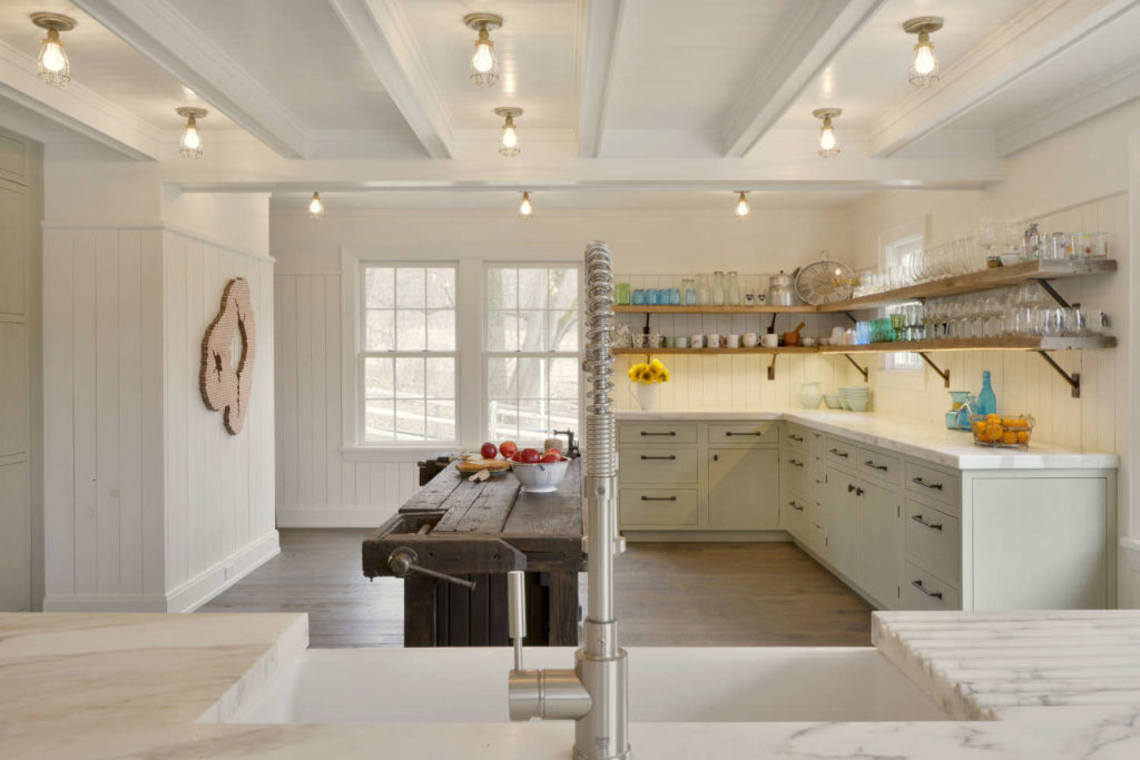 Farmhouse Kitchen features individual brass caged light bulbs instead of recessed lighting