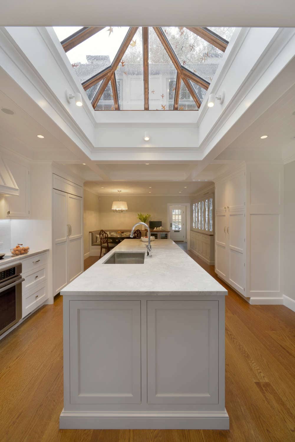 Elegant kitchen features Rutt cabinetry and center island, quartz countertops and pyramid skylight.