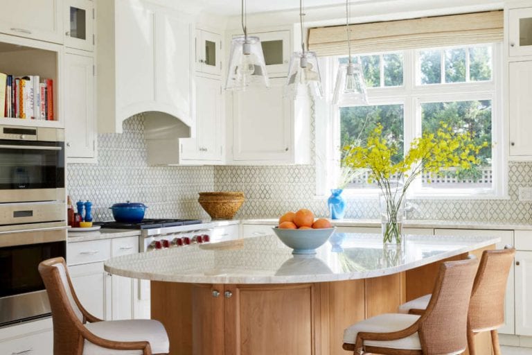 Scandinavian inspired kitchen features white Rutt cabinetry and contoured natural cherry island with mother-of-pearl quartz countertop.