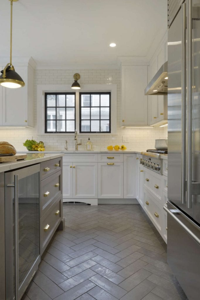 Kitchen features erringbone floor tile and white Caesarstone topped white NAC cabinetry.