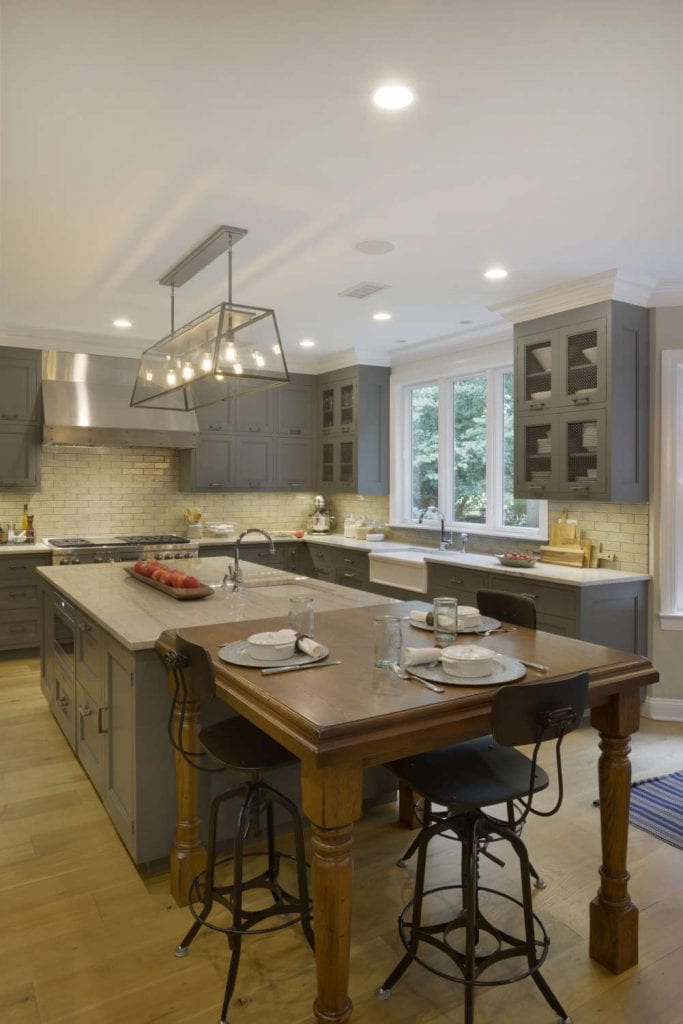 Classic country kitchen features grey Bilotta cabinetry, glazed brick subway tile and reclaimed wood flooring.