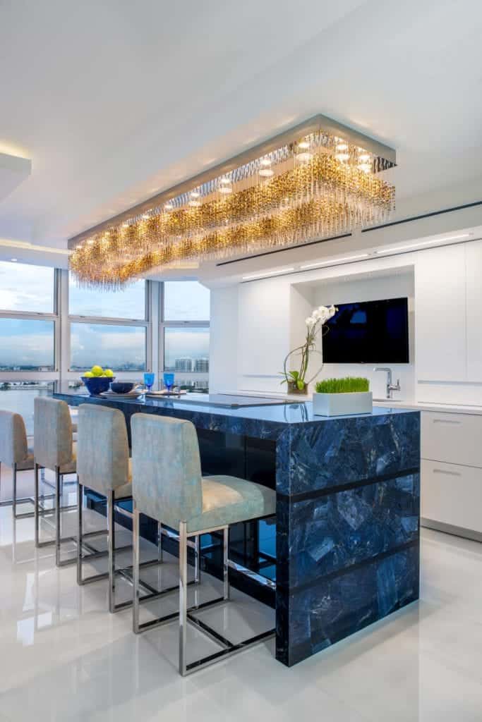 Florida Blue & White Kitchen features sapphire blue jeweled Galaxy Glass countertop with a waterfall end, inlaid with horizontal glossy black bands.