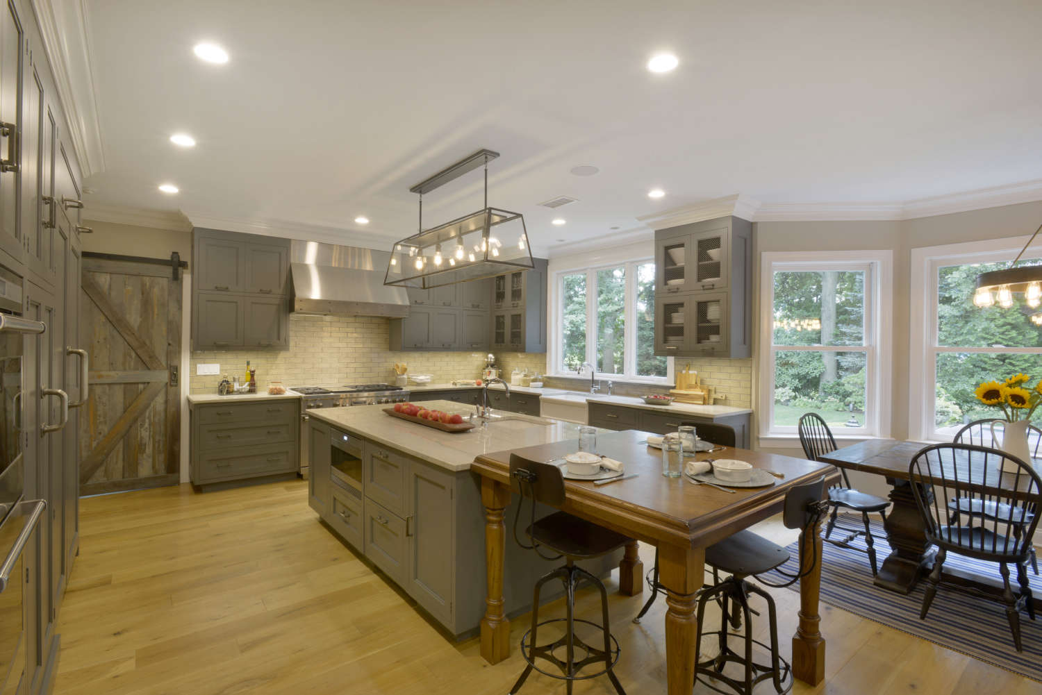 Classic country kitchen features gray Bilotta cabinetry, glazed brick subway tile and reclaimed wood flooring.