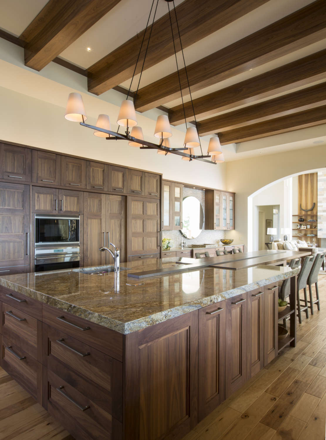 Classic kitchen features natural walnut Rutt cabinetry, custom island with Juparana granite countertop and pine flooring.