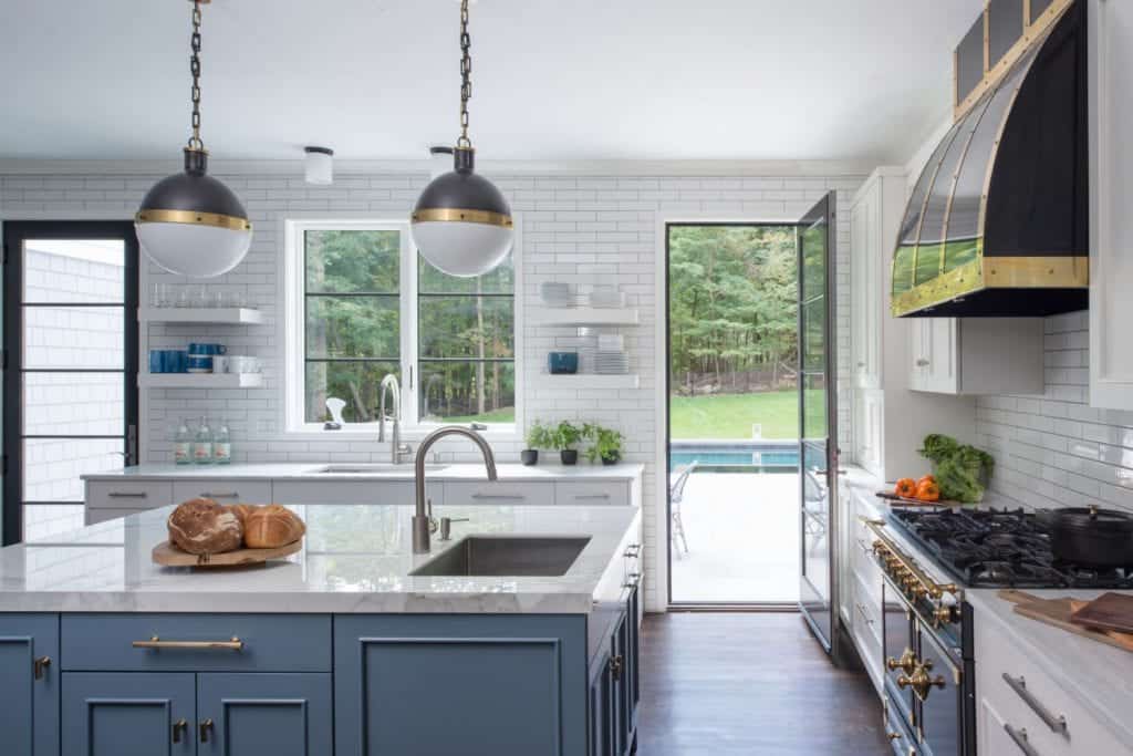 White & Blue Kitchen with brass hardware and black and brass hood.