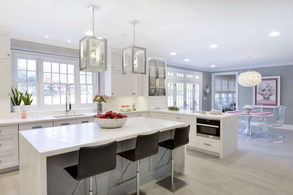 Clean and classic all-white kitchen features white diamond marble countertop, white Bilotta cabinetry and super white custom island.
