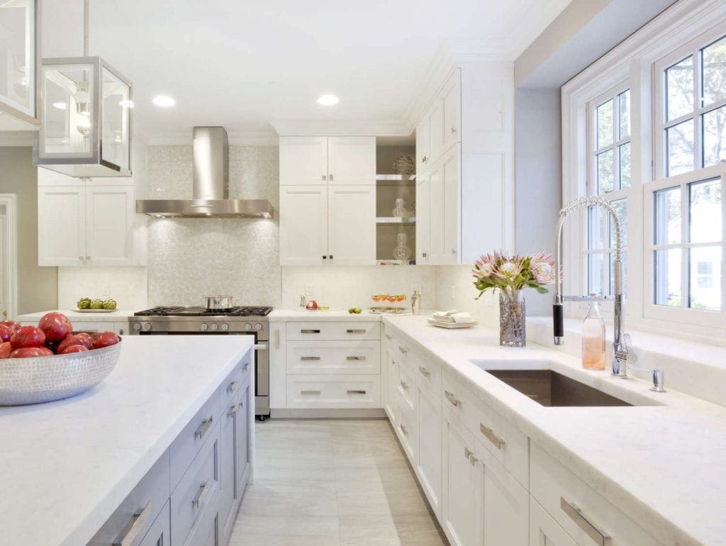 Clean and classic all-white kitchen features white diamond marble countertop, white Bilotta cabinetry and super white custom island.