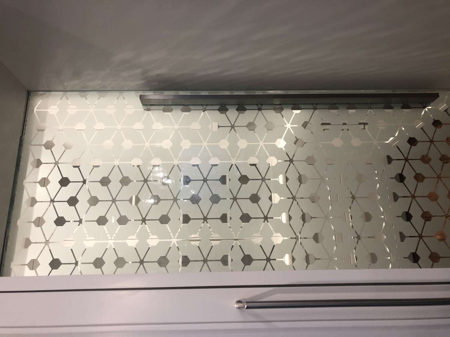 Decorative glass pantry door with stainless pull.