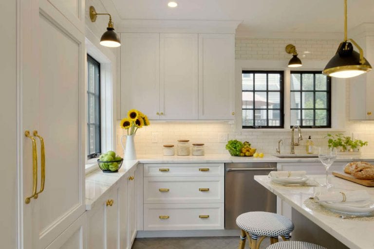 Kitchen features white Bilotta cabinetry with brass hardware and herringbone patterned floor tile.