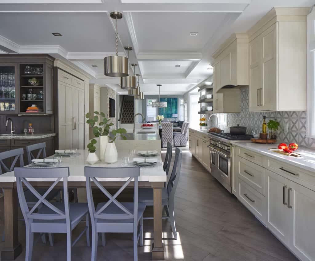 Traditional kitchen features silver canister pendant lights, coffered ceiling and white painted Bilotta cabinets with a subtle glaze.