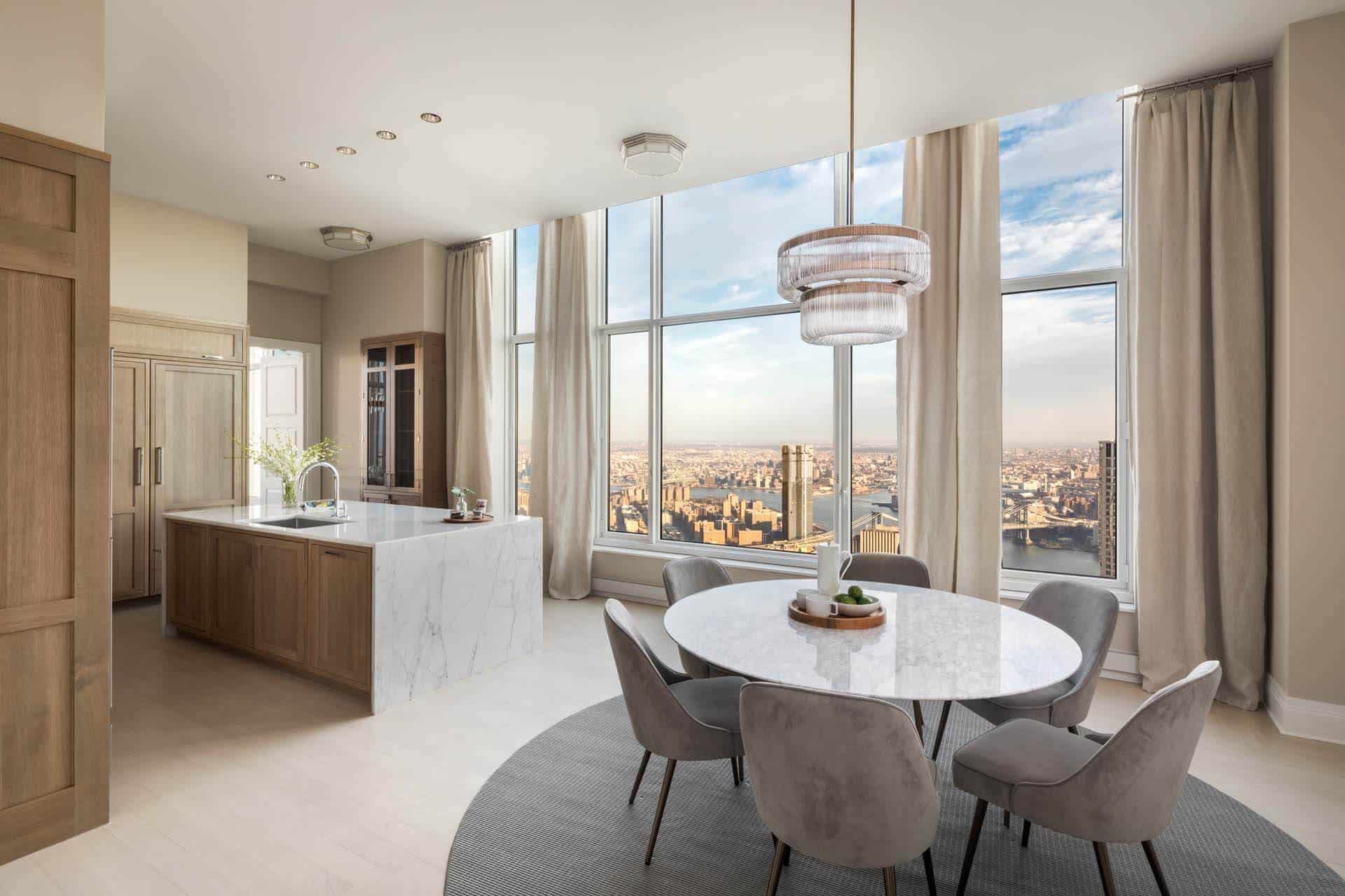 Multi-unit residential kitchen condo features NYC skyline view, Bilotta Collection cabinetry and marble-topped island with waterfall.