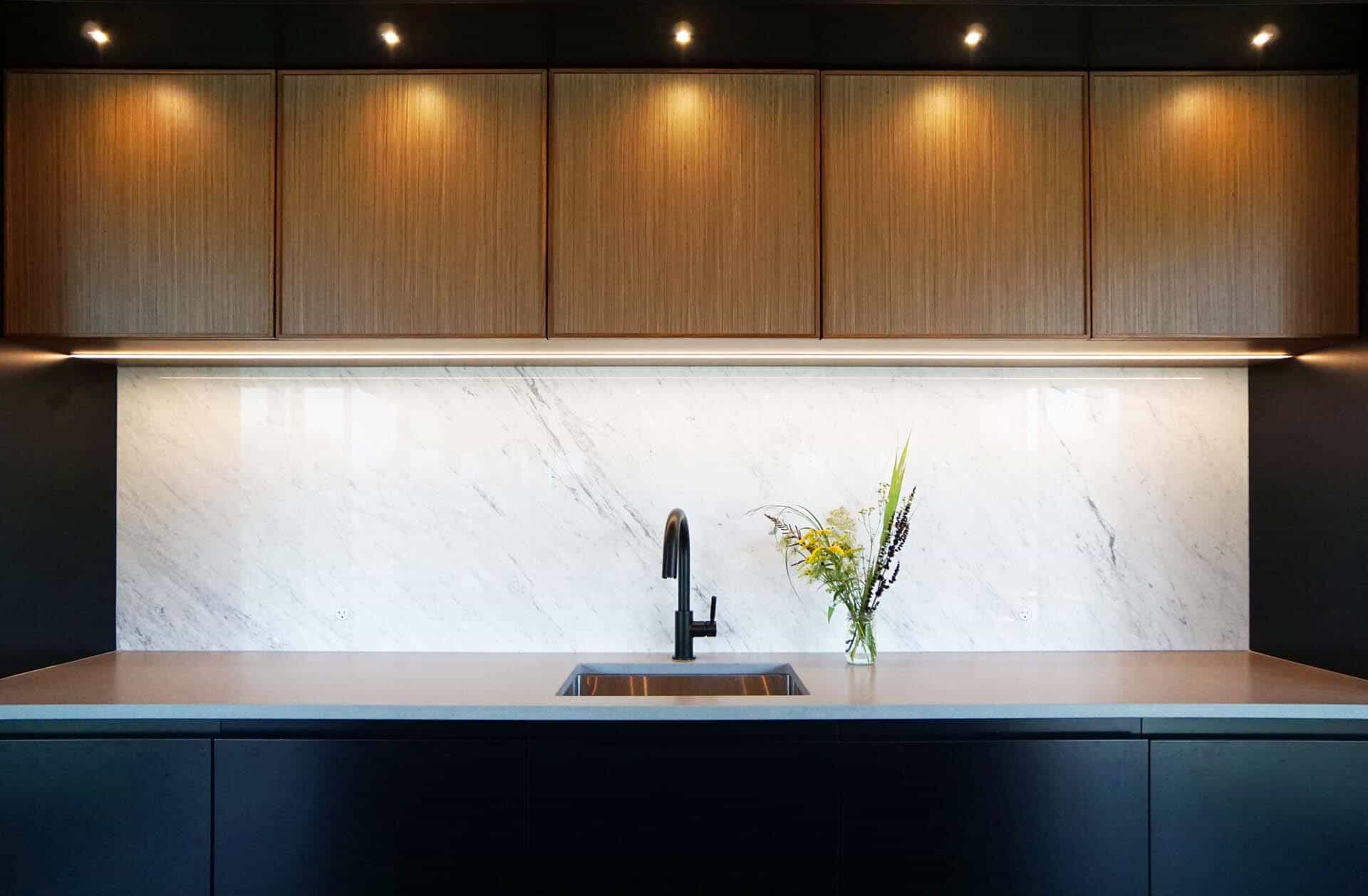 Concrete quartz countertop and Carrera backsplash veining echo the outside landscape of this mid-century modern kitchen.