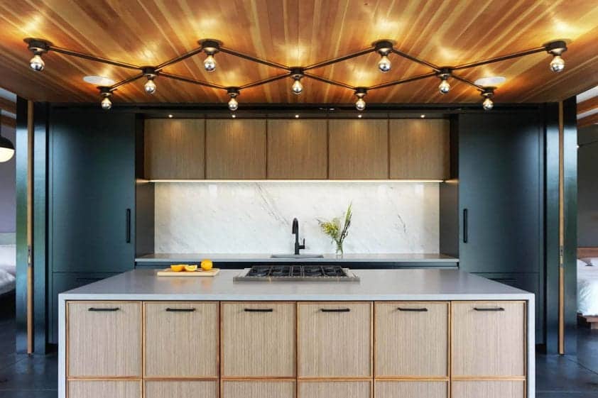 Mid-century modern kitchen features distinctive cabinets of natural walnut quarter-sawn veneer trimmed with walnut solid stock.