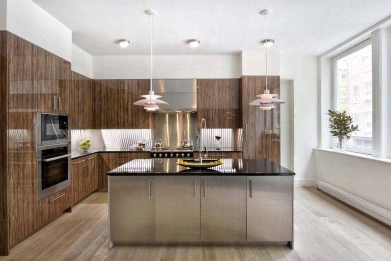 European-inspired kitchen features task lighting, dramatic pendant lights, Alumasteel center island and vertical grained high gloss olivewood Artcraft cabinets.