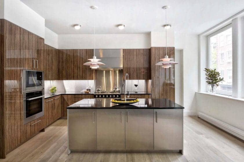 European-inspired kitchen features dramatic pendant lights, Alumasteel center island and vertical grained high gloss olivewood Artcraft cabinets.