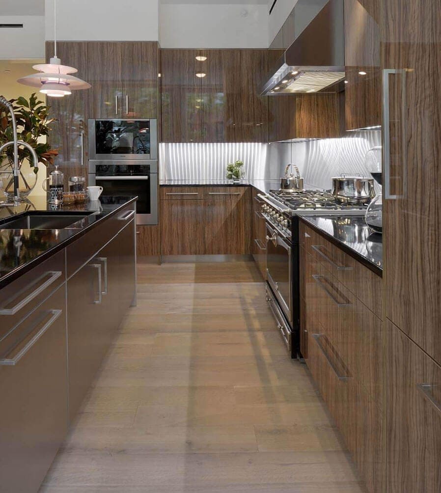 Contemporary NYC kitchen features vertical grained, high gloss olivewood Artcraft cabinetry and black lavastone countertop.