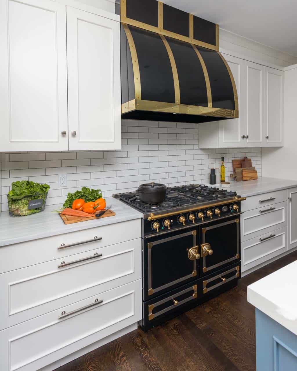 Classic kitchen features Bilotta custom cabinets, chrome and brass hardware and black and brass La Cornue range and hood.