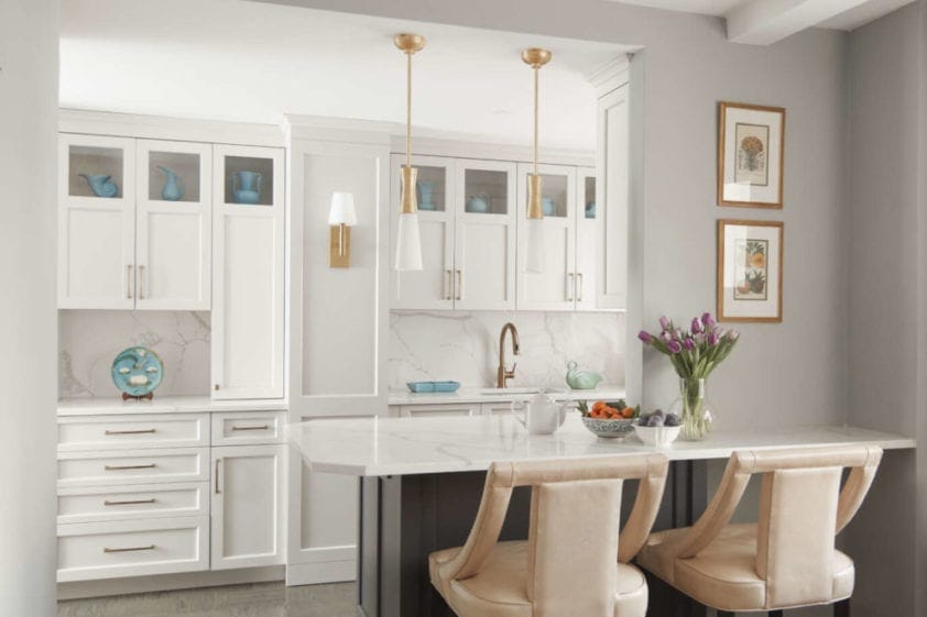 Kitchen features white painted Bilotta cabinets and burnished brass and soft grey accents