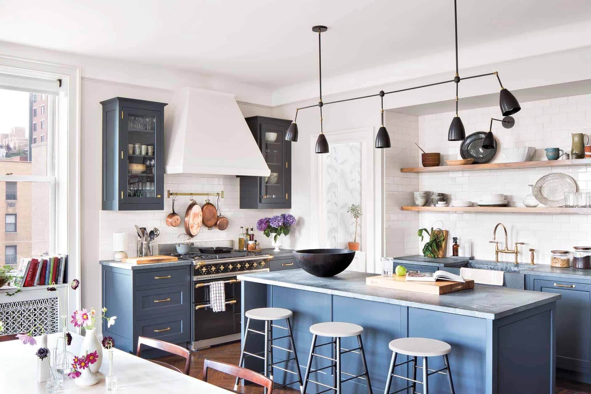 Classic New York City kitchen features blue painted Bilotta cabinets, white subway tile walls and open shelving.