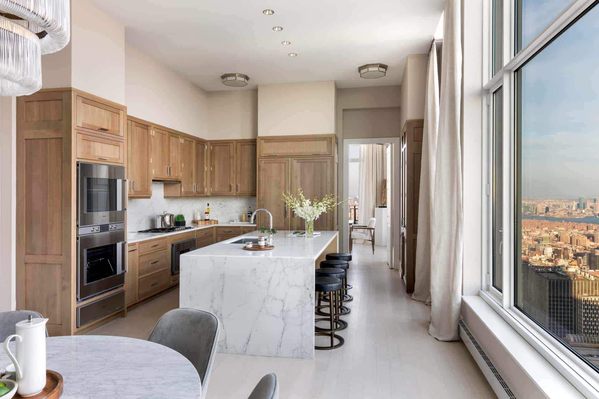 Luxury NYC condo kitchen features Bilotta Collection Cabinetry in rift cut white oak with a custom stain.