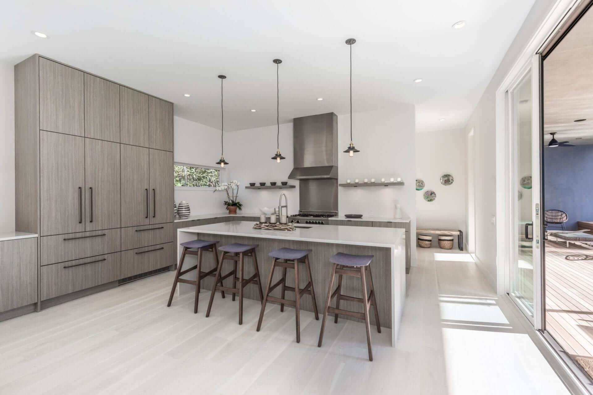 Grey Nantucket vertical laminate Brookhaven cabinetry lends a modern vibe to this monochromatic open kitchen.