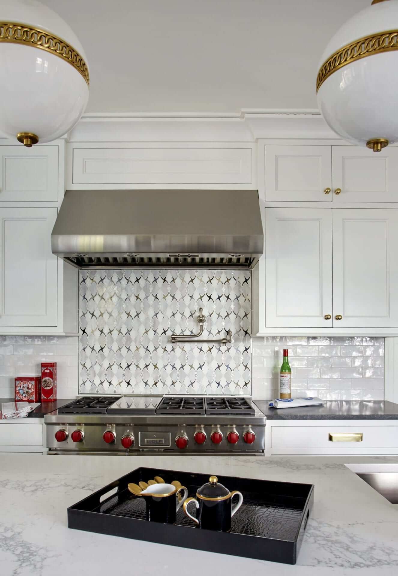 Art Deco inspired kitchen features white Bilotta cabinetry with brass hardware and brass accented lighting