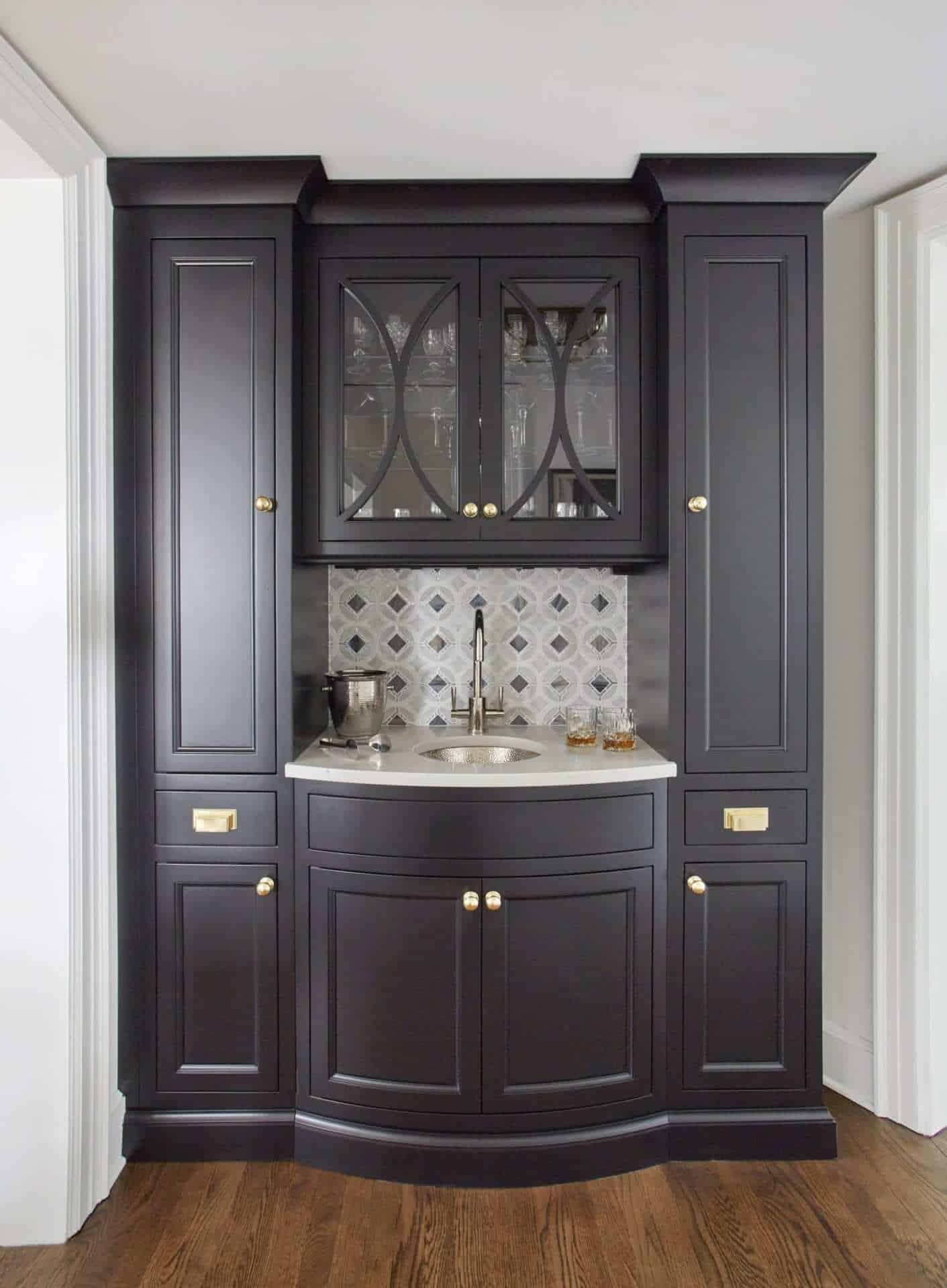 Butler's pantry features black Bilotta cabinetry with Statuario Maximus Caesarstone countertop, brass hardware and patterned tile backsplash.