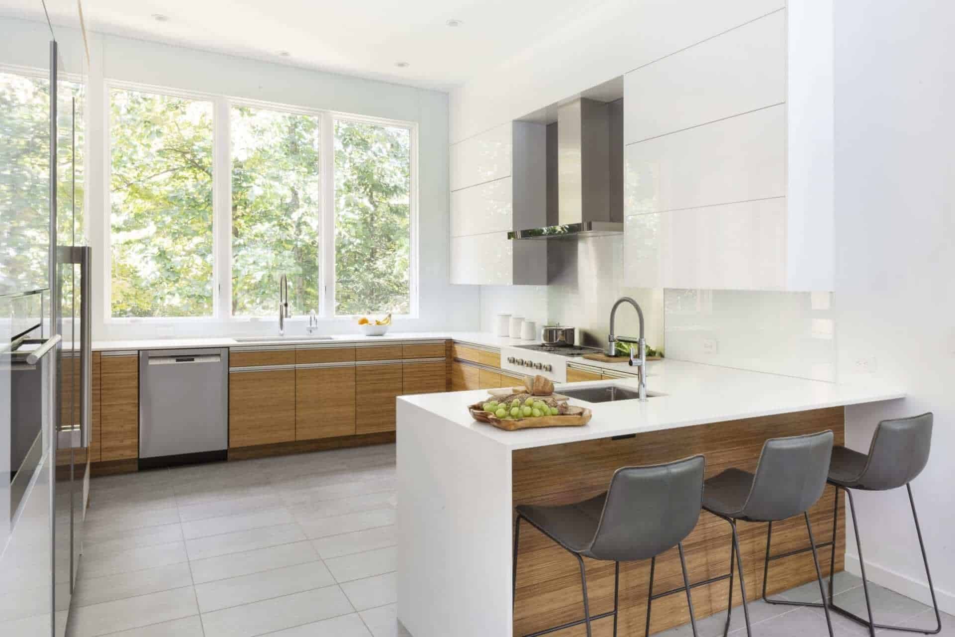 U-shaped modern kitchen in White Plains features NAC flat front cabinets, white Caesarstone quartz countertops and stainless appliances.