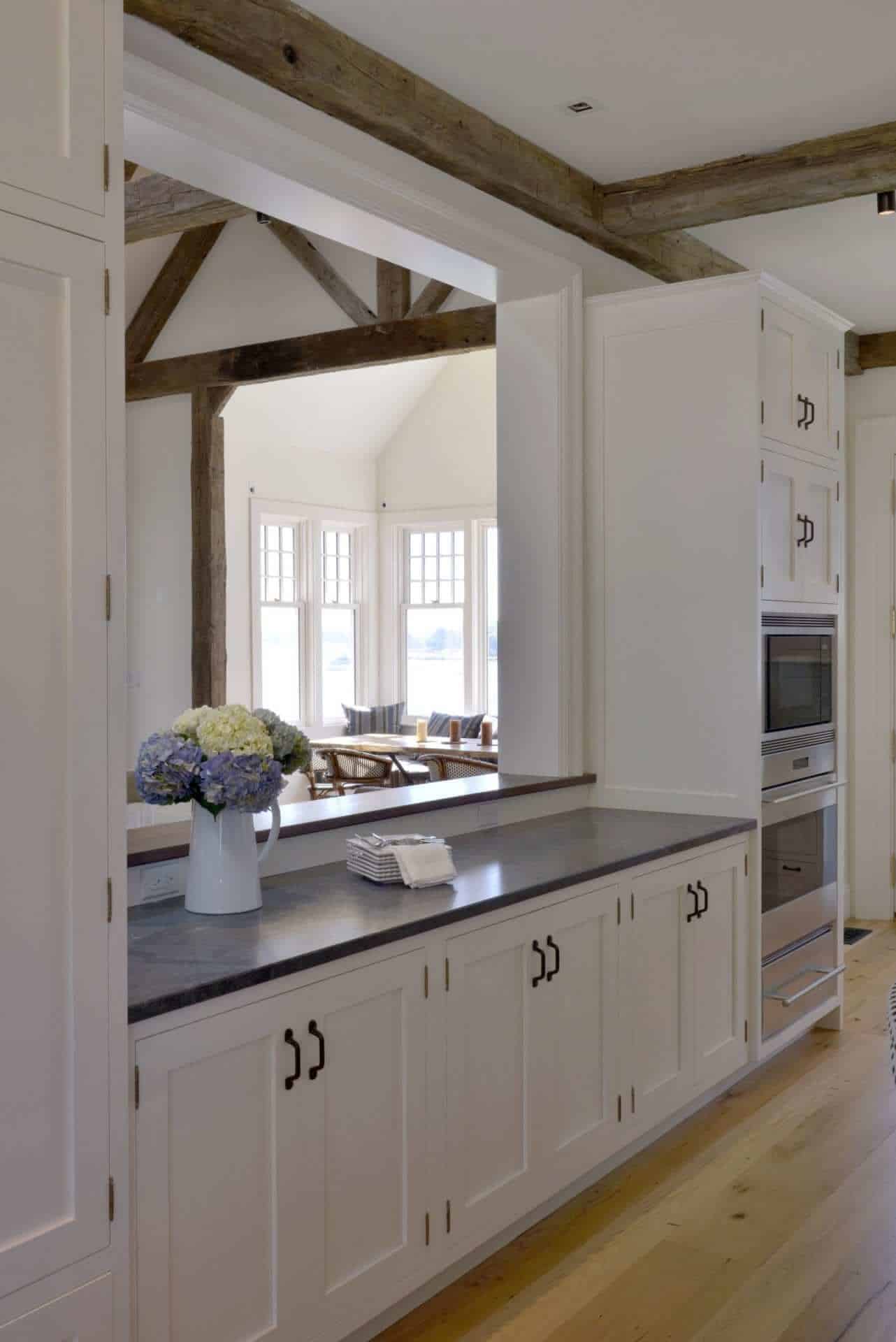Classic kitchen features Jet Mist granite topped white Bilotta cabinetry and oak flooring.