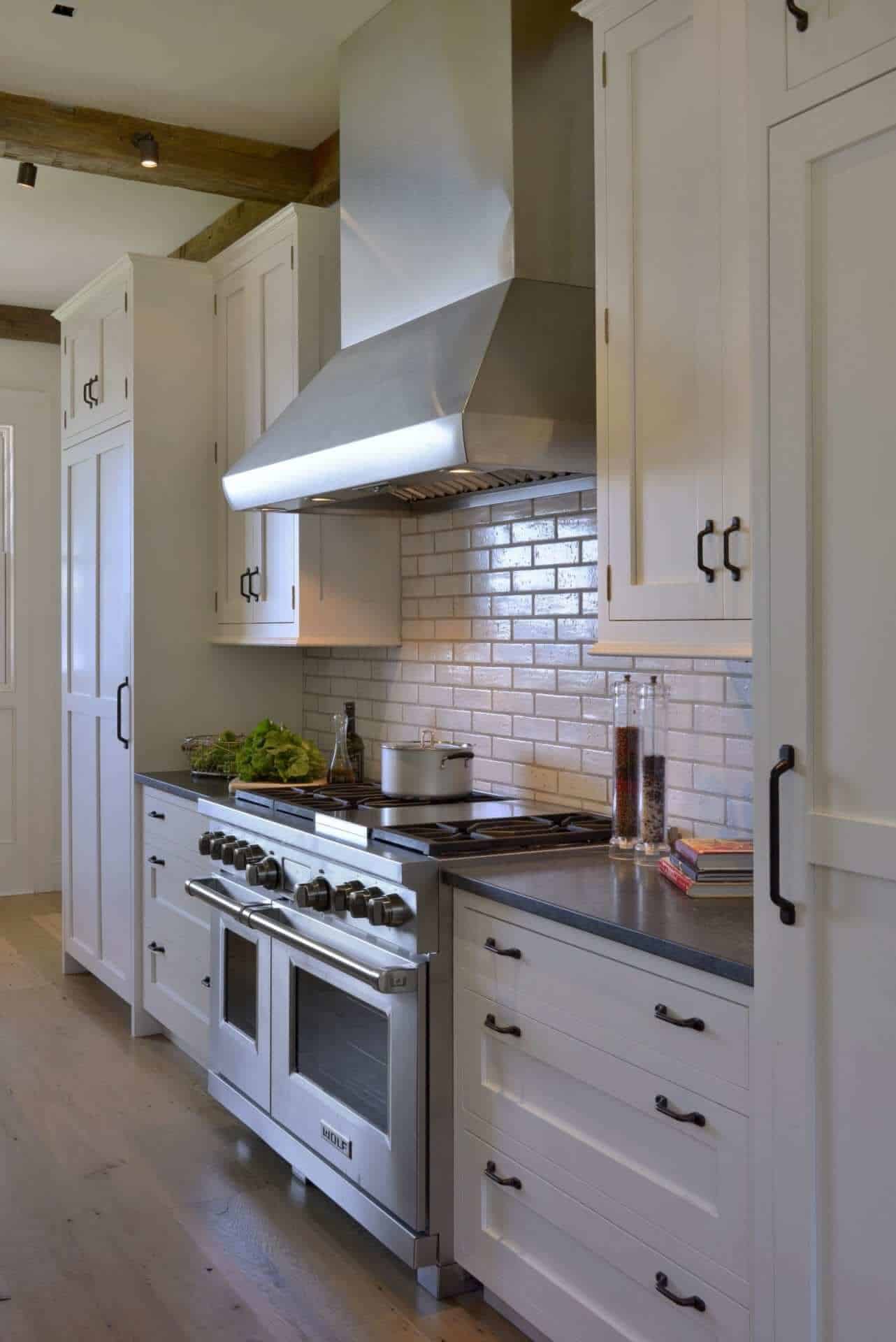 Crisp classic kitchen features white Bilotta cabinetry, large stainless hood and white Grove Brickworks subway tile backsplash.
