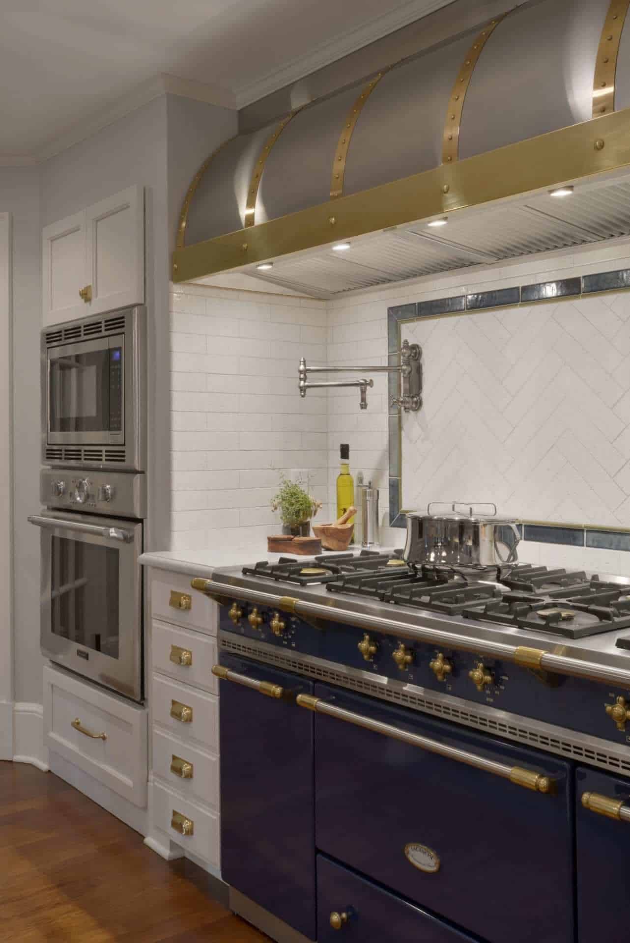Expansive Bilotta kitchen features La Cornue range with brass accented hood and Kyoto White and Kyoto Steel backsplash by Artistic Tile.